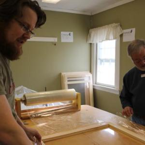 Jo Van de Velde of Belgium and Denny Hebert of Wiscasset work on window inserts. Van de Velde is the son-in-law of Susan Van Alsenoy of Wiscasset. Courtesy of Freya Van de Velde