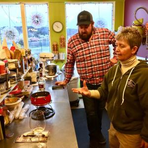 Kim Martin talks cheese fondue to her friend Michael Maxim in Eventide Specialties’ kitchen. SUZI THAYER/Boothbay Register