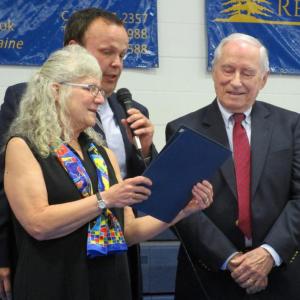 Selectmen Allison Hepler and Jason Shaw present John Chapman, right, with the town's 2018 “Spirit of America” award at Woolwich’s annual town meeting April 28. Chapman is a former Maine legislator and selectman and is the longtime town meeting moderator. PHIL DI VECE/Wiscasset Newspaper