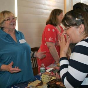 Mystery writer Lea Wait and a fan share a laugh at the Books in Boothbay event July 14. LISA KRISTOFF/Boothbay Register