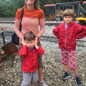 With help from mother Jennifer Moore, Chicago's Gus Moore, 3, cover his ears as they and Gus’s brother Harry, 8, witness a train being prepared for a run. SUSAN JOHNS/Wiscasset Newspaper