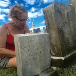 Denise Bizer cleans stones at Alna Cemetery Sept. 13. According to the one in the foreground, Adelaid, daughter of Moses and Octavie Bragdon, died 150 years ago this month, at 1. SUSAN JOHNS/Wiscasset Newspaper