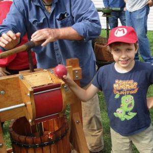 Wiscasset's Ed Kavanagh works the cider press with help from Farmingdale's Josh Grant who was spending the weekend with his grandparents. PHIL DI VECE/Wiscasset Newspaper