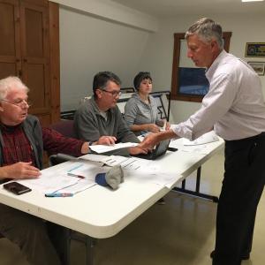 CMP's Massachusetts project spokesman John Carroll passes Alna Third Selectman Doug Baston a handout of his presentation. Also pictured are Second Selectman Ed Pentaleri and First Selectman Melissa Spinney. SUSAN JOHNS/Wiscasset Newspaper