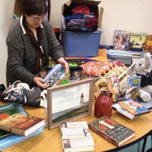 French teacher Irene Marchenay unpacks items for Saturday’s garage sale at Wiscasset Middle High School. PHIL DI VECE/Wiscasset Newspaper