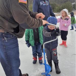 Preschoolers and their families drill through the ice while exploring the wetlands at DRA’s Great Salt Bay Farm. Courtesy of DRA