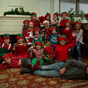 Peter Havas (stars as Sandy), center, and his elves celebrate Christmas in "The Santa Diaries.” Dave Mention photo
