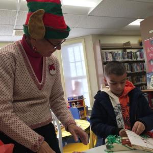 Wiscasset's Jan Whitfield helps Damariscotta's Owen Allen, 7, of Damariscotta prepare a gift downstairs in Wiscasset Publlic Library Dec. 8. SUSAN JOHNS/Wiscasset Newspaper