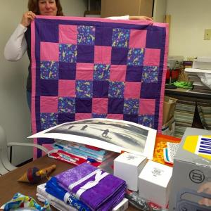 At Wiscasset Community Center Jan. 25, Parks and Recreation Director Lisa Thompson shows some of the items headed for a silent auction at Winterfest. SUSAN JOHNS/Wiscasset Newspaper