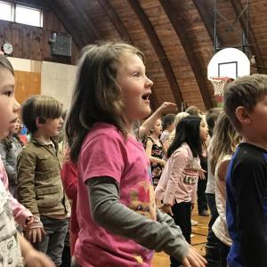 From left, kindergarteners Jackson Bluteau, Emma Stewart and Dykenn Howard sing about fruits and vegetables in Wiscasset Elementary School’s closing ceremonies for WinterKids Feb. 7. SUSAN JOHNS/Wiscasset Newspaper