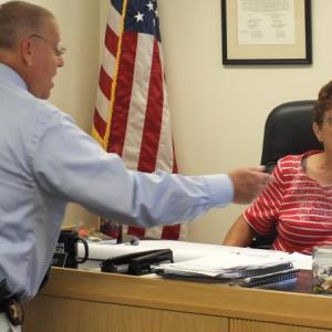 Lincoln County Sheriff Todd Brackett provides Commissioner Mary Trescot with information Aug. 6 about two potential new deputy sheriff hires. BILL PEARSON/Boothbay Register