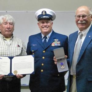 Douglas Bowers, left, and Fred Bowers, far right, family of Justin P. Wiley, accept the Purple Heart on behalf of Wiley’s family. Coast Guard Northern New England Sector Command Master Chief Christopher H. James, center, presented the award. Ross Ragan photo