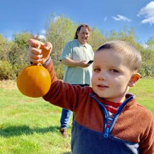 Avery Robertson, 3, of Jefferson chose this pumpkin because “it has a stick.” Behind him is grandmother Cheryl Bois. SUSAN JOHNS/Wiscasset Newspaper