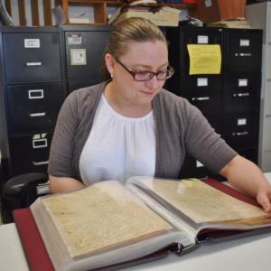 Town Clerk Chelsea Lane looks at Woolwich’s earliest birth and death records dating from 1731 to 1835, which have been newly restored. PHIL DI VECE/Wiscasset Newspaper