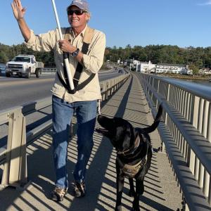 Edgecomb’s Stott Carleton and his black lab Skip take the American flag over Donald E. Davey Bridge and back Monday. SUSAN JOHNS/Wiscasset Newspaper