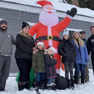 From left, Alton King III, wife Jean and their children Allyson, Hannah, Nevaeh, Mckayla, Alton IV and Mathew enjoy their new Santa Dec. 20 in the family’s Alna yard, where another Santa disappeared last week. SUSAN JOHNS/Wiscasset Newspaper