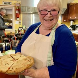About five months before the COVID-19 pandemic halted events like these, Morris Farm’s Madelyn Hennessey brings out her apple-cherry pie at the nonprofit’s Nov. 2, 2019 silent auction and bean supper. File photo