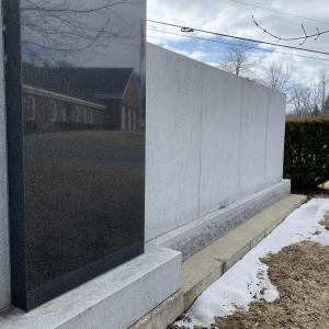Snow recedes and the center of the veterans’ wall reflects Wiscasset’s municipal building March 9. SUSAN JOHNS/Wiscasset Newspaper