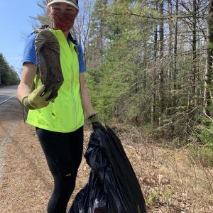 Maria Jenness makes a find on Route 218 April 24 in the town-wide roadside cleanup she organized in Alna. SUSAN JOHNS/Wiscasset Newspaper
