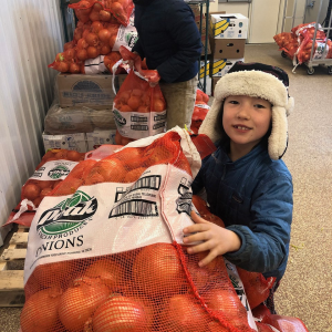 Twin Villages Foodbank Farm co-founder Megan Taft and daughter Adley process a shipment of onions at the food storage hub. Courtesy of Hannah McGhee