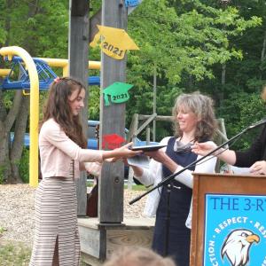 It was a big day on June 14 for Eva Whitmore. She graduated sixth grade and received two awards. Here she is receiving the Arts Award from music teacher Jennifer McIvor, center, and integrated arts teacher Robin MacCready. BILL PEARSON/Boothbay Register