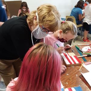 Kathy Faass, standing, helps students create a painting on wood. JANE CARPENTER/Boothbay Register