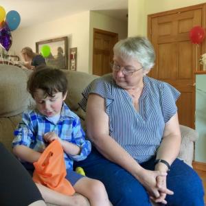 Jameson Brooks, 10, pulls a balloon from a bag at his birthday party July 24 as his longtime pen pal Sophie Dear looks on. SUSAN JOHNS/Wiscasset Newspaper