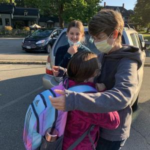 Elizabeth Freeman shares a first day back at school hug with daughters Haley Dumais, 10, foreground, and Lily Dumais, 12, in the Wiscasset Elementary School lot Tuesday morning, Sept. 7. SUSAN JOHNS/Wiscasset Newspaper