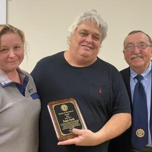 Ralph Smith, center, with wife Elena receives a plaque from Post Commander David Patch. Jim Singer photo