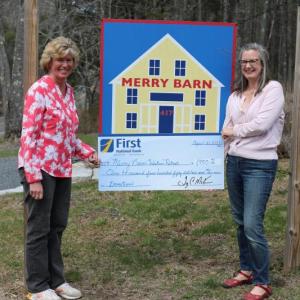 Brenda Blackman, left, of First National Bank presents a mock check to Stephanie McSherry of Merry Barn. Courtesy photo