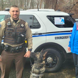 Deputy Jon Colby, K9 Bear and Leslie Livingston, Healthy Kids executive director, standing by the Lincoln County Sheriff’s cruiser with a Supporting Families/Preventing Abuse decal on it for Child Abuse Prevention Month. Courtesy photo