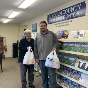 Dylan Huggins, employee of Wiscasset and Boothbay self storage units, and Mary Ellen Barnes, executive director of the Lincoln County Regional Planning Office in Wiscasset, hold donations for the food drive. Courtesy photo