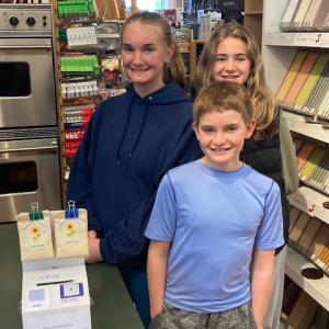 Nora, Iris and Desmond Conlin at retail partner, Now You’re Cooking in Bath, with a Maine For Ukraine display. Courtesy photo