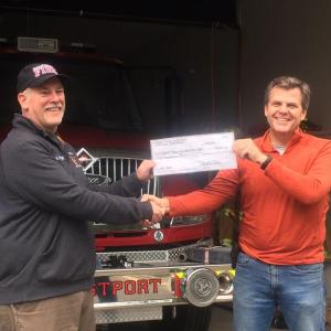 Westport Volunteer Fire Department Chief Stacey Hutchison, left, accepts a check from Race Director Rob Whitney on behalf of Westport Island Shore Run Association in 2021. Courtesy photo