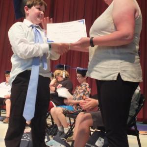 Edgecomb School Committee’s Heather Sinclair claims her son had a regular size tie when he left for school on June 16, but she is all smiles as she awards Myles Ian Sinclair-Whitfield his sixth grade diploma. BILL PEARSON/Boothbay Register