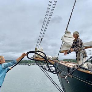 Wiscasset visitor Katy Petersen, left, throws a rope to When and If crew member Luana Santana Aug. 18 when the Wiscasset-built schooner arrived for Schoonerfest. SUSAN JOHNS/Wiscasset Newspaper