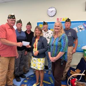 At Wiscasset Elementary School Sept. 21, American Legion Post 54 of Wiscasset Cmdr. William Cossette Jr. presents Principal Kathleen Pastore with the post’s $1,000 donation to aid pre-K teacher Samantha Crawford’s family. Also pictured are, front right, educational technician Patricia Hanley, and back, starting second from left, Post 54 members John Kennedy, Neil Page, Bob Milligan and Cliff Hendricks. Courtesy photo