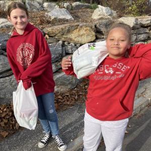 Fifth graders Alex Herrick, left, and Tayia Wright carry
donated food. EDNA MILLER/Wiscasset Newspaper
