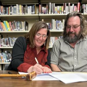 Wiscasset’s next superintendent of schools Kim Andersson signs her contract March 22 as School Committee Chairman Jason Putnam looks on. Jodi Hardwick photo