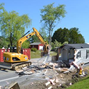 A work crew cleans up debris following a two-vehicle crash on Route 1 in Wiscasset Wednesday, May 31. Johnathan Riley photo