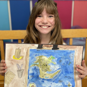 Lucie Hollan holds "A Dragon's Map of Pantala," which was selected as a Top Twelve finalist in Osher Map Library's annual Mapmaking Contest. Courtesy photo
