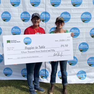 Becky Winslow from Gorham Savings Bank, left, presents a check to Erica Berman at the Maine Marathon. Nayara Dalossi photo