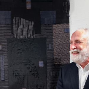 Textile artist Michael Olszewski is shown with his fabric collage at the opening of the Maine Art Gallery's current show, "The Artful Interior." Bob Bond photo Textile artist Michael Olszewski