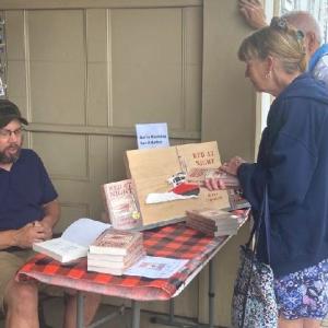Author Jerry Farnham outside Sherman’s Bookstore in Boothbay Harbor signing copies of his first novel, “Red At Night,” during the annual Windjammer Days Festival in late June last year. Courtesy of the author
