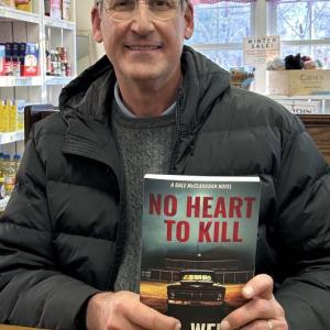 Charlie Britton, aka C. W. Wells, with his latest book, “No Heart to Kill.” JENNY BENNETT/Boothbay Register