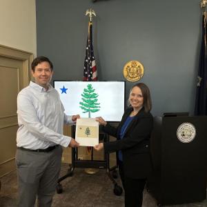 Secretary of State Shenna Bellows with Adam Lemire of Gardiner, winner of the Maine State Flag Redesign Contest. Courtesy photo