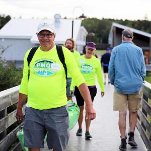 Volunteers haul kayaks to the water as they prepare to support the swim portion of the Pemaquid Beach Triathlon in 2023. Courtesy of Coastal Rivers
