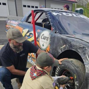 Peter Kolbe and Arrow of Light Scout Jereimiah Raposa change a tire. Courtesy photo 