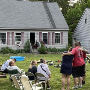 Ed Crocker, in red, holds wife Candie at the scene of the fire that heavily damaged their home. FRITZ FREUDENBERGER/Boothbay Register