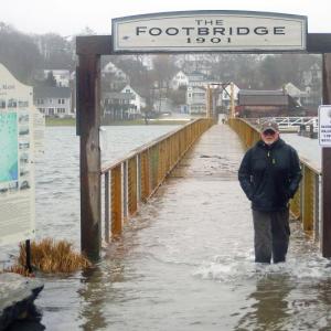 Dick Morrison crosses the flooded footbridge during a January storm. STEVE EDWARDS/Boothbay Register